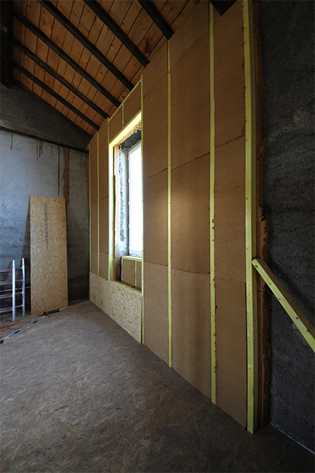 Isolation des murs machefer avec une première couche continue et deuxième couche entre ossature bois